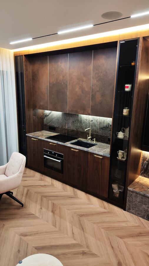 Apartament po sprzątaniu poremontowym: ciemna zabudowa kuchenna i jodełka